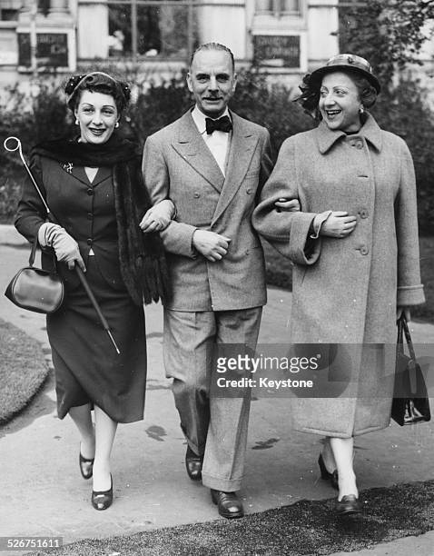 Italian actors Andreina Pagnani, Sergio Tofano and Margherita Bagni, walking arm in arm through London following an invite from Sir Laurence Olivier,...