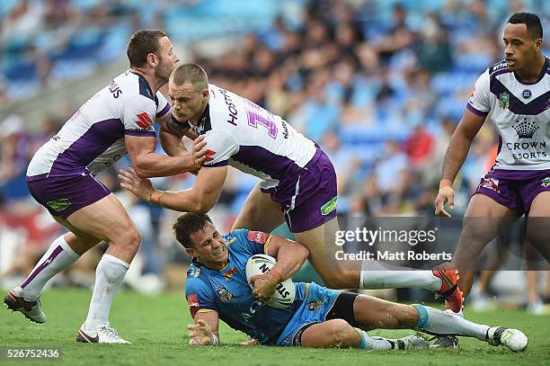 William Zillman of the Titans is tackled during the round nine NRL match between the Gold Coast Titans and the Melbourne Storm on May 1, 2016 in Gold...