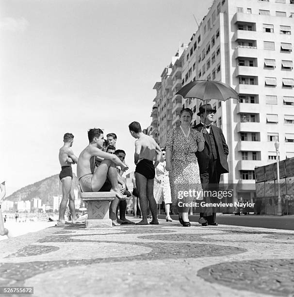 Older Couple Passing Young Beachgoers on Sidewalk, Copacabana Beach, Rio de Janeiro, circa 1955.