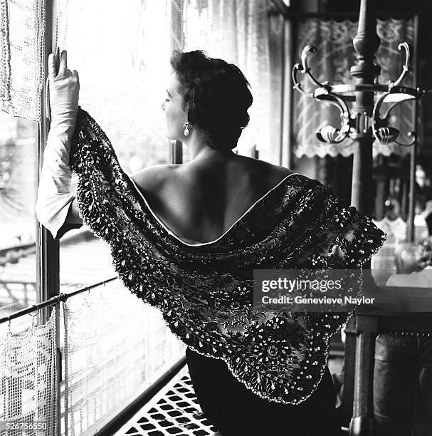 Woman models an ornately beaded shawl designed by Givenchy. 1954.