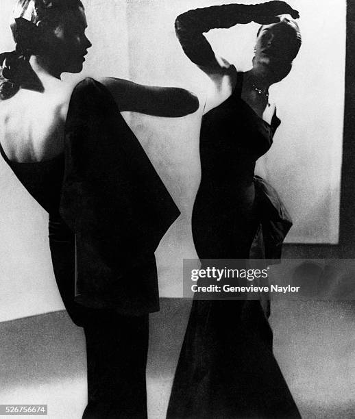 Two women model evening gowns for the 1949 Schiaparelli collection. New York, New York.