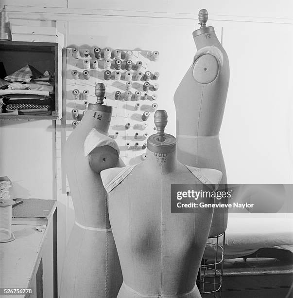 Dressmaker's dummies stand near a board filled with spools of thread in a designer's shop in Manhattan.
