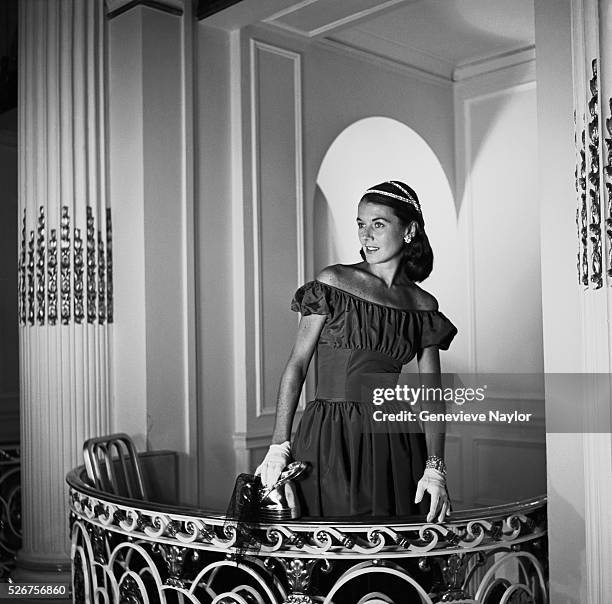 Sabine models a single, black bodice evening dress accented by Hattie Carnegie jewelry on one of the Plaza Hotel ballroom balconies for Harper's...