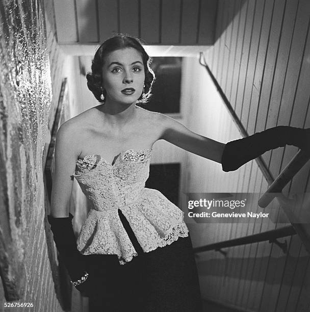 Actress Suzy Parker models a white cotton on black velvet evening gown by Anna Miller.
