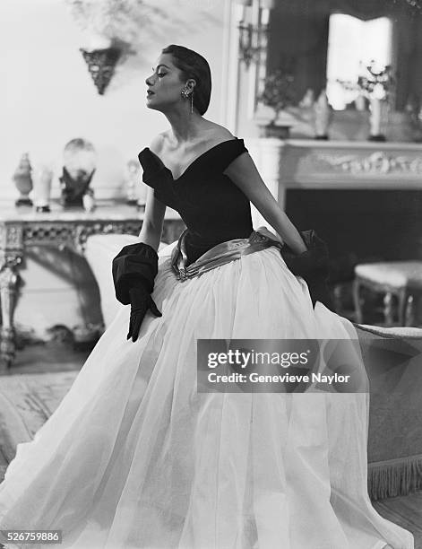 Woman models a ball gown with a white skirt and black top.