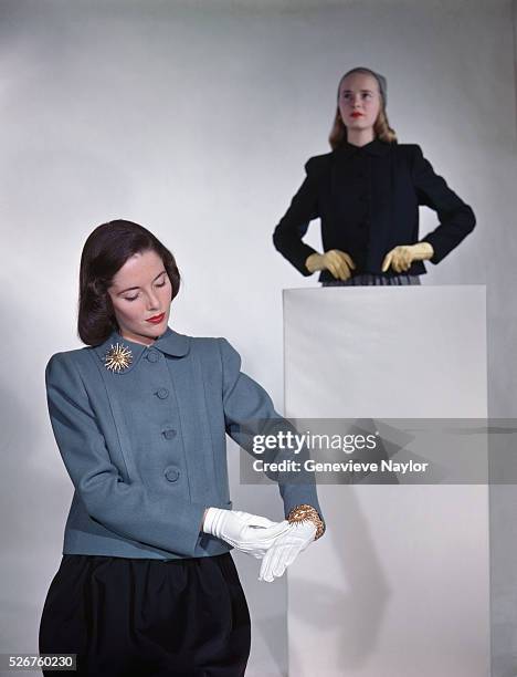 Two fashion models model new fall coats designed by Henry Brendel, gloves designed by Van Raalte, and costume jewelry designed by Van Cleef & Arpels.