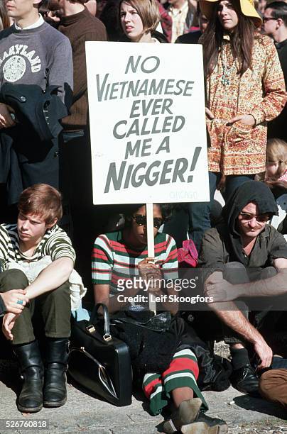 Black protester at an anti-Vietnam War rally holds up a pro-Vietnamese sign against American racism.