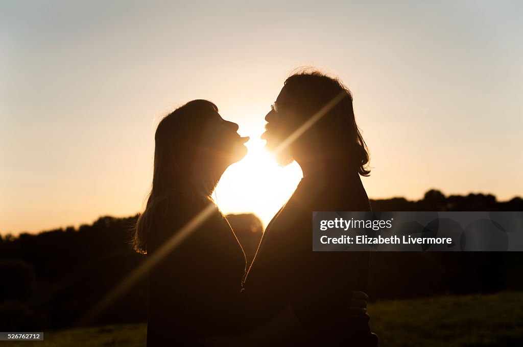 Couple standing in front of a sunset