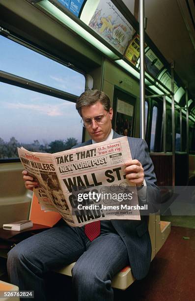 Commuter reads the New York Post's rundown of Wall Street's 1987 stock market crash.