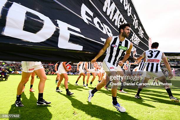 Alex Fasolo of the Magpies breaks the banner during the 2016 AFL Round 06 match between the West Coast Eagles and the Collingwood Magpies at Domain...