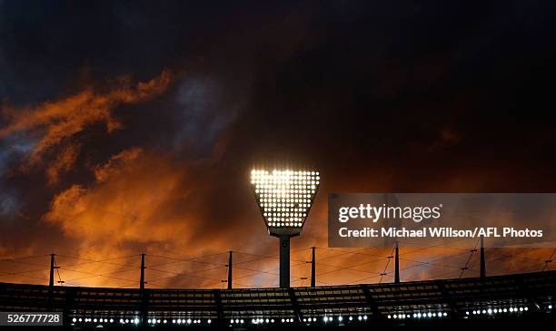 The sun sets behind the MCG light tower during the 2016 AFL Round 06 match between the Carlton Blues and the Essendon Bombers at the Melbourne...