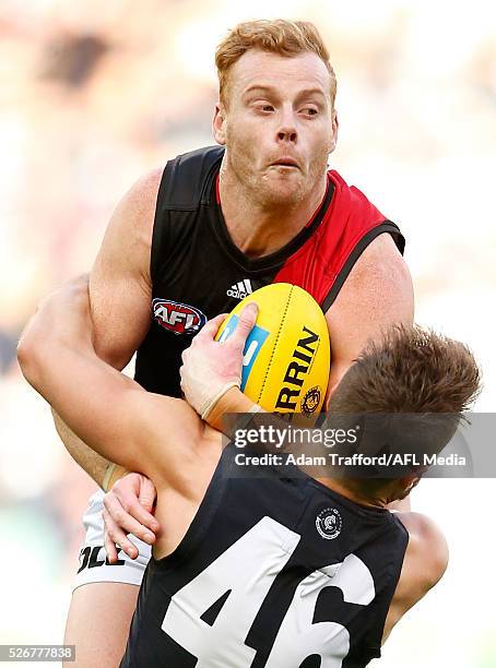 Adam Cooney of the Bombers is tackled by Matthew Wright of the Blues during the 2016 AFL Round 06 match between the Carlton Blues and the Essendon...