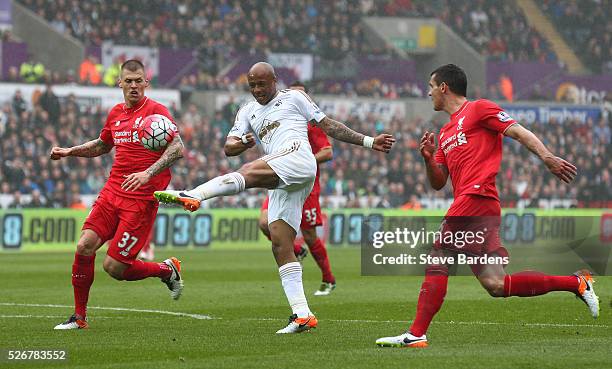 Andre Ayew of Swansea City misses an early chance at goal watched by Martin Skrtel of Liverpool during the Barclays Premier League match between...