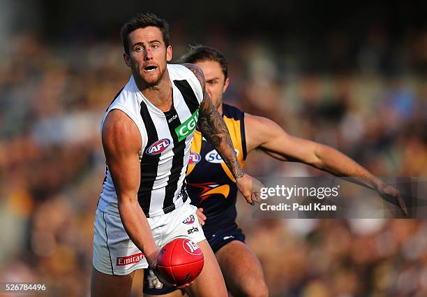 Jeremy Howe of the Magpies handballs during the round six AFL match between the West Coast Eagles and the Collingwood Magpies at Domain Stadium on...