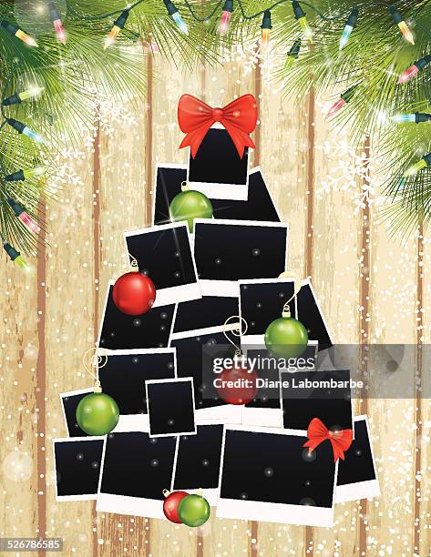 photos christmas tree and evergreens on wood background - christmas picture frame stock illustrations