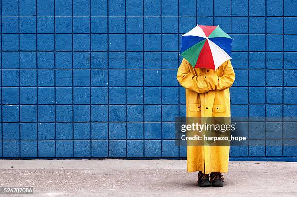 umbrella hat and raincoat disguise. - nascondere la testa nella sabbia foto e immagini stock