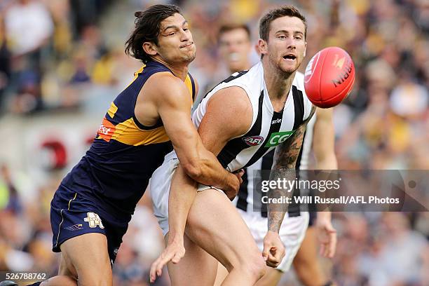 Jeremy Howe of the Magpies handballs under pressure from Sharrod Wellingham of the Eagles during the round six AFL match between the West Coast...