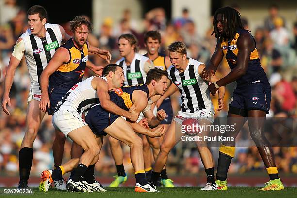 Jack Redden of the Eagles gets his handball away while being tackled by Levi Greenwood of the Magpies during the round six AFL match between the West...