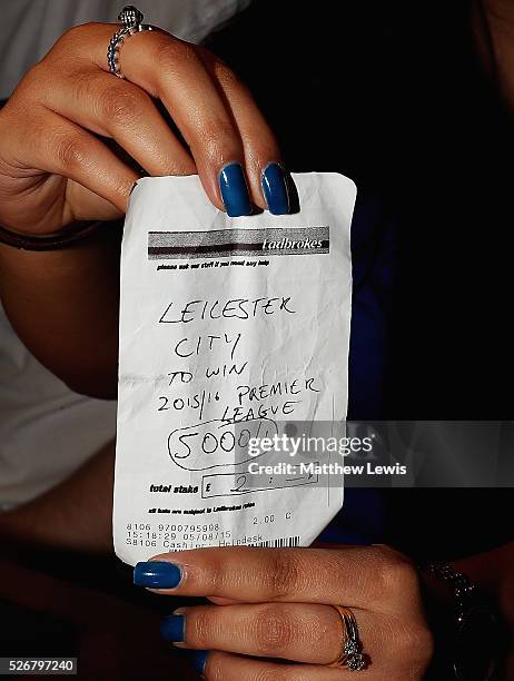 Karishma Kapoor a Leicester City supporter shows off her betting slip as Leicester City fans gather in the Local Hero pub to watch their match...