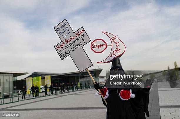 Demonstrator dressed up in a 'burka' protests against AfD the Alternative fuer Deutschland political party federal congress on April 30, 2016 in...