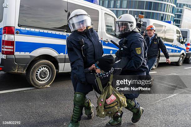 Police forces take a protestor into custody during a demonstration against a party congress of the German right wing party AfD at the Stuttgart...