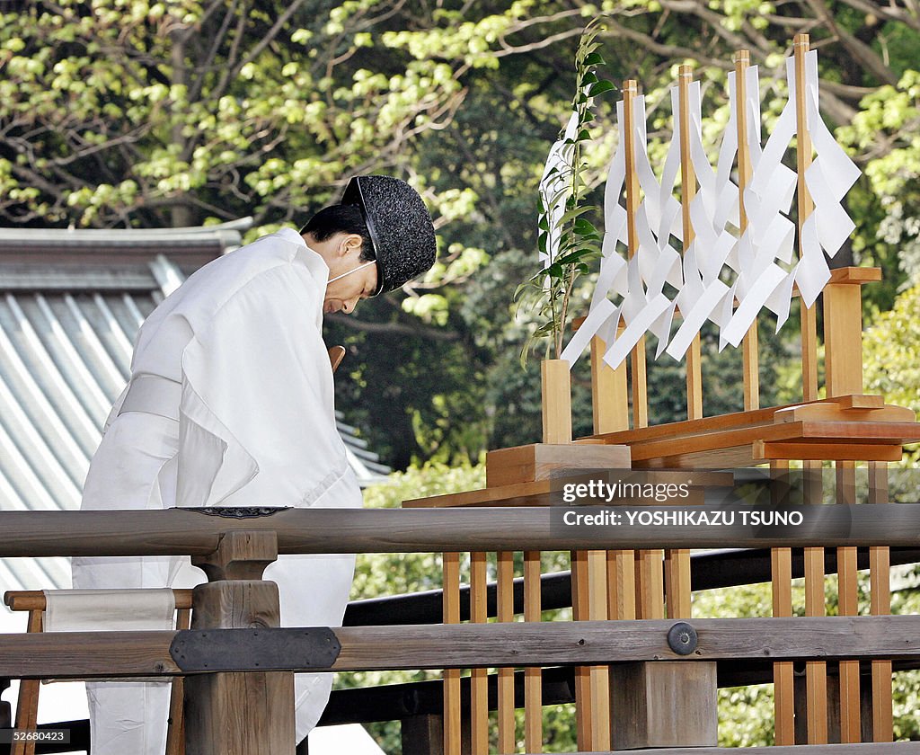 A Shinto priest bows in a ritual at Toky