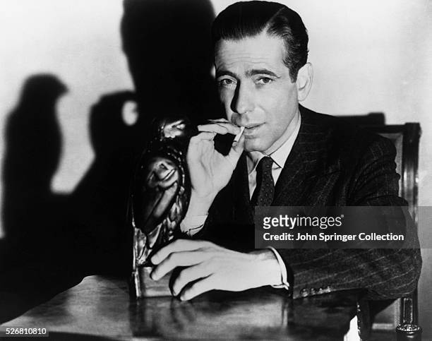 Publicity still from John Huston's "The Maltese Falcon" shows Humphey Bogart as Sam Spade sitting with the object of the title. Motion pictured...