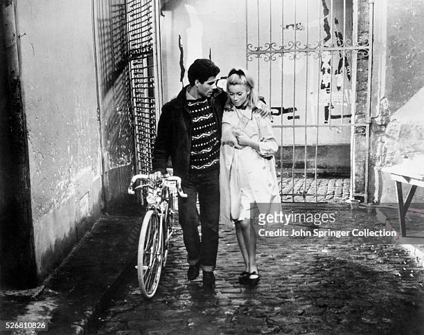 Genevieve Emery walks through a courtyard with Guy , whom she loves but her mother has forbidden her to marry. Released: 1964.