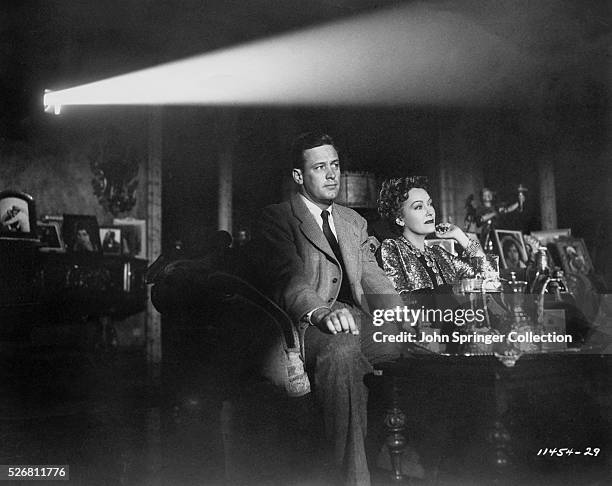William Holden as Joe Gillis and Gloria Swanson as Norma Desmond watch a film in the 1950 drama Sunset Boulevard.