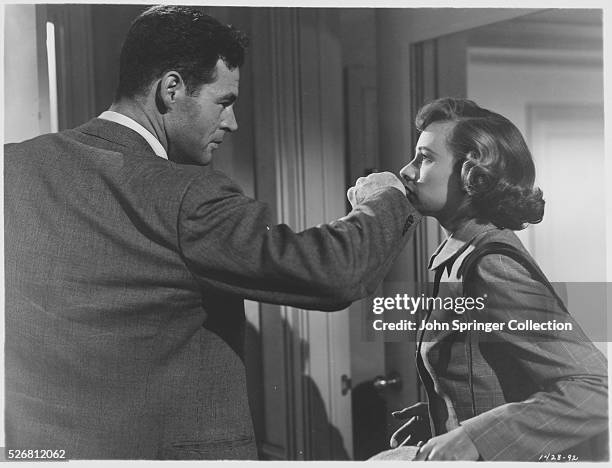 Joe Parkson prepares to cover Ann Sturges' mouth with his hand.