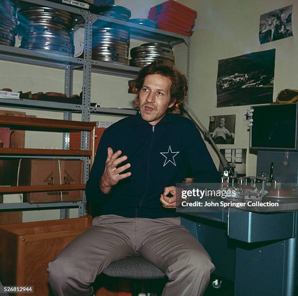 Director Werner Herzog seated at a film splicing machine, 1970.