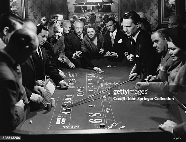 Jim Kurstyn and Ada stand at the end of the craps table surrounded by other players.