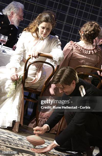 Madeleine Worrall watches an actor spin a large top in a scene from the new production of Chekhov's "Three Sisters" at the Playhouse Theatre.