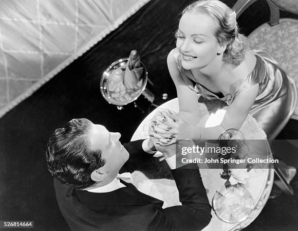 Fred MacMurray and Carole Lombard Holding Hands