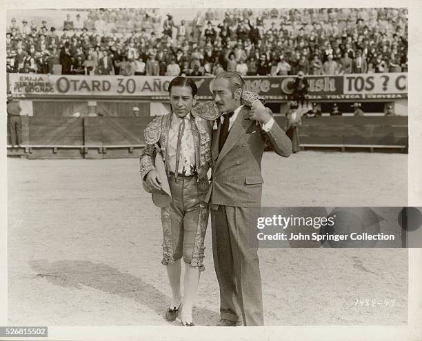 Adolphe Menjou helps George Raft off the bullfighting arena in a scene from the 1934 film The Trumpet Blows.