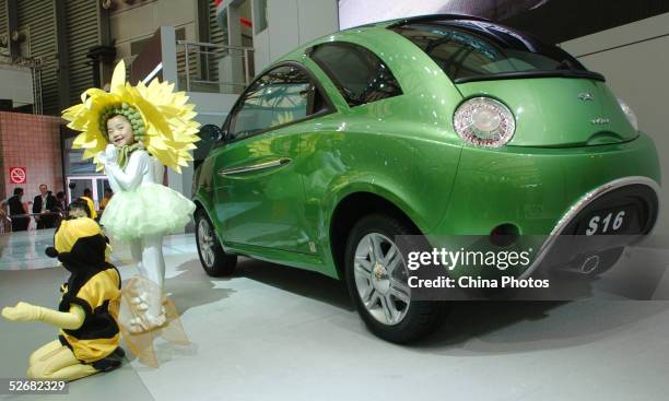 Children pose with a SAIC Chery S16 car at the Auto Shanghai 2005 Exhibition on April 21, 2005 in Shanghai, China. Top world automakers are...