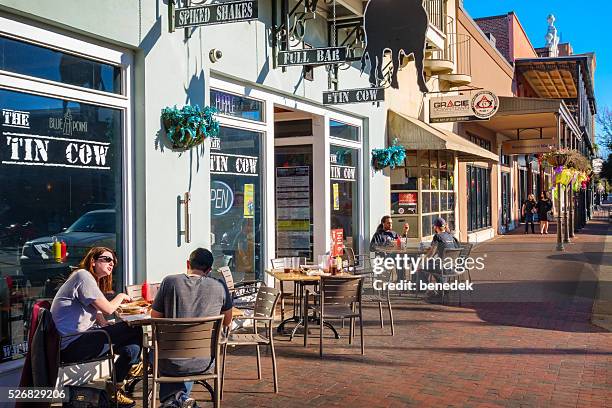 people have food at restaurant patio in downtown pensacola florida - pensacola florida stock pictures, royalty-free photos & images