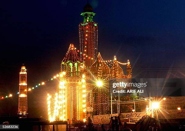 Pakistani Muslim devotees arrive at a illuminated mosque to pray during the Eid-e-Milad-un-Nabi, the birthday of Prophet Mohammad, celebrations in...