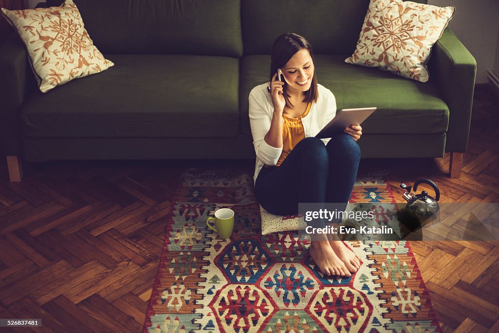 Young woman reading a tablet and listening her messages