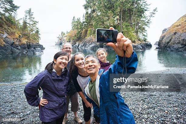 multi-ethnic hiking family posing for selfie on remote wilderness beach - backpacker travel stock pictures, royalty-free photos & images