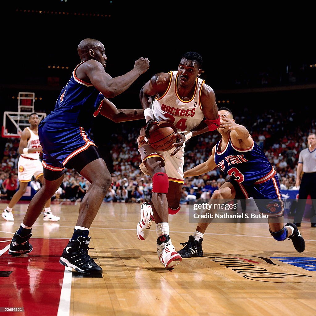 Hakeem Olajuwon Of The Houston Rockets Drives Between John Starks And hakeem-olajuwon-of-the-houston-rockets-drives-between-john-starks-and