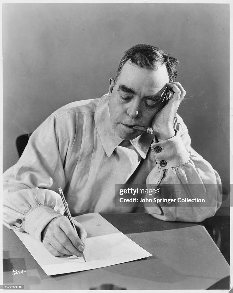Novelist Irvin S. Cobb Writing and Smoking Cigar