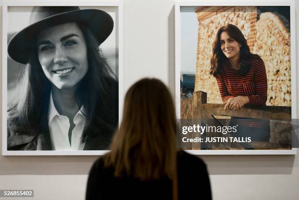 Visitor looks at two new portraits of Catherine, Duchess of Cambridge, taken in the Norfolk Countryside by British photographer Josh Olins, at the...