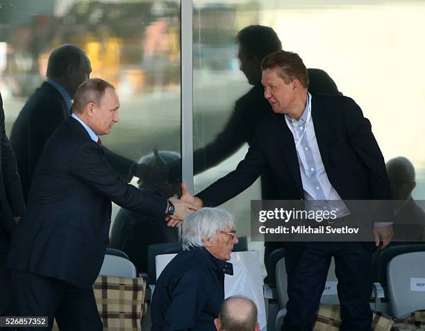 Russia's President Vladimir Putin greets Gazprom's CEO Alexei Miller during the Formula One Russian Grand Prix at the Sochi Autodrom racetrack ON May...