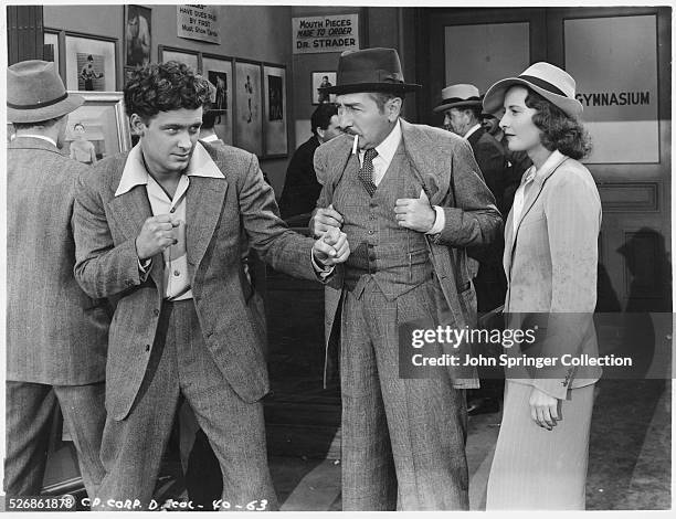 William Holden shadow boxes while Adolphe Menjou and Barbara Stanwyck watch in the 1939 film Golden Boy.