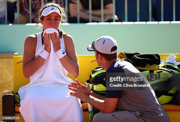 Johanna Konta of Great Britain shows her emotions as she talks with her coach Esteban Carril just prior to withdrawing from her first round match...
