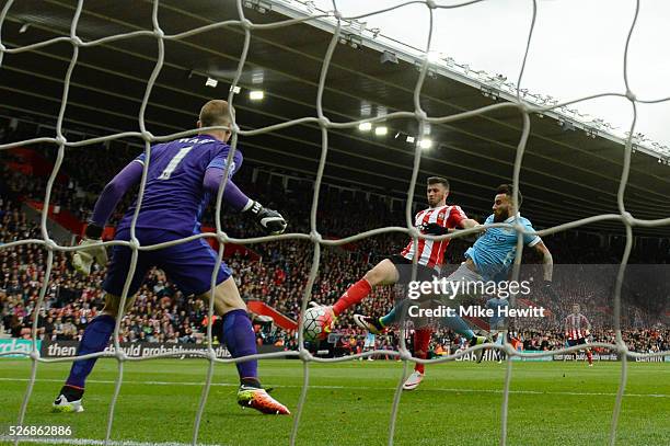 Shane Long of Southampton beats Nicolas Otamendi and Joe Hart of Manchester City as he scores the opening goal during the Barclays Premier League...