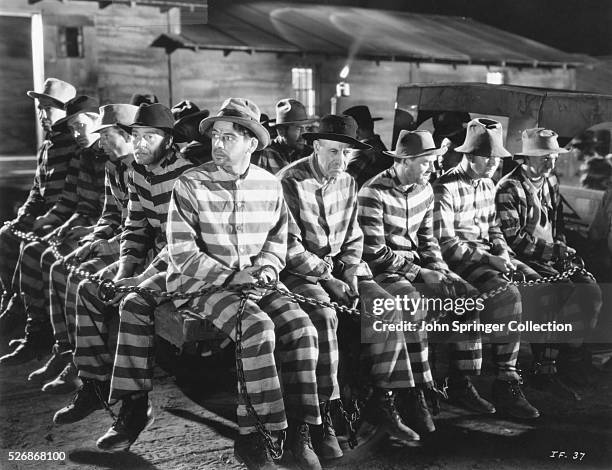 Prisoners in a chain gang at a prison in the 1932 film I Am a Fugitive From a Chain Gang. Wrongly convicted James Allen, played by Paul Muni, serves...