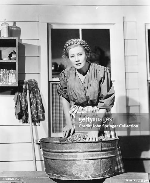Actress Irene Dunn washes clothes in a washtub on a porch in a scene from the 1948 film I Remember Mama. Dunn stars as Mama of the Norweigian Hansen...