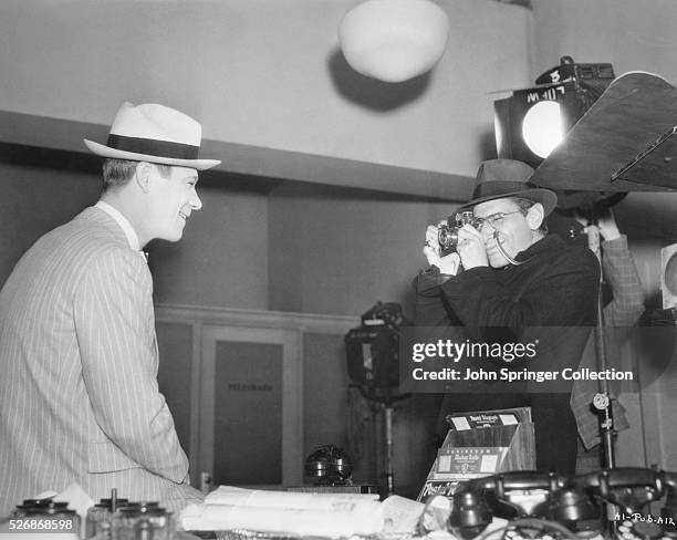 Producer David L. Loew takes a picture of actor Joe E. Brown between scenes of Riding on Air .